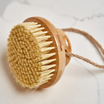 Body brush with wooden handle and natural bristles on a light background