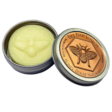 Bee bar lotion in a tin with 'Honey House Naturals' branding on a white background