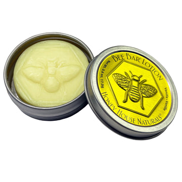 Bee bar lotion in a metal tin with 'Honey House Naturals' branding on a white background