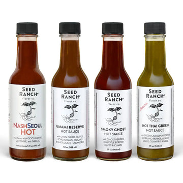 Four bottles of Seed Ranch hot sauce on a white background