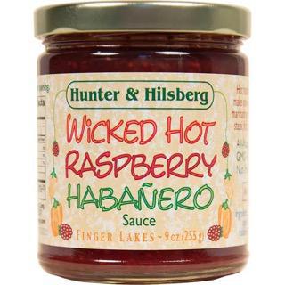 A jar of Wicked Hot Raspberry Habanero Sauce by Hunter & Hilsberg. The label shows the product name, raspberries, and habanero peppers, and indicates it is gluten-free, GMO-free, and suitable for vegans.