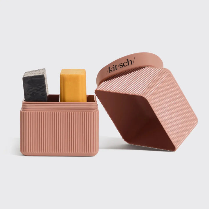 Pink soap holder with two bars of soap inside, on a light gray background