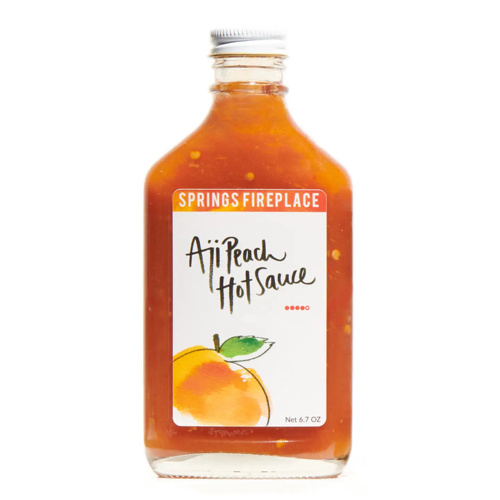 Bottle of Springs Fireplace Aji Peach Hot Sauce on a white background