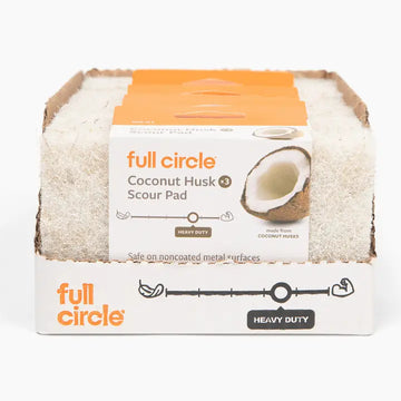 A retail display box of Full Circle Coconut Husk Scour Pads, showing multiple beige coconut husk pads stacked inside a white cardboard package with orange branding.