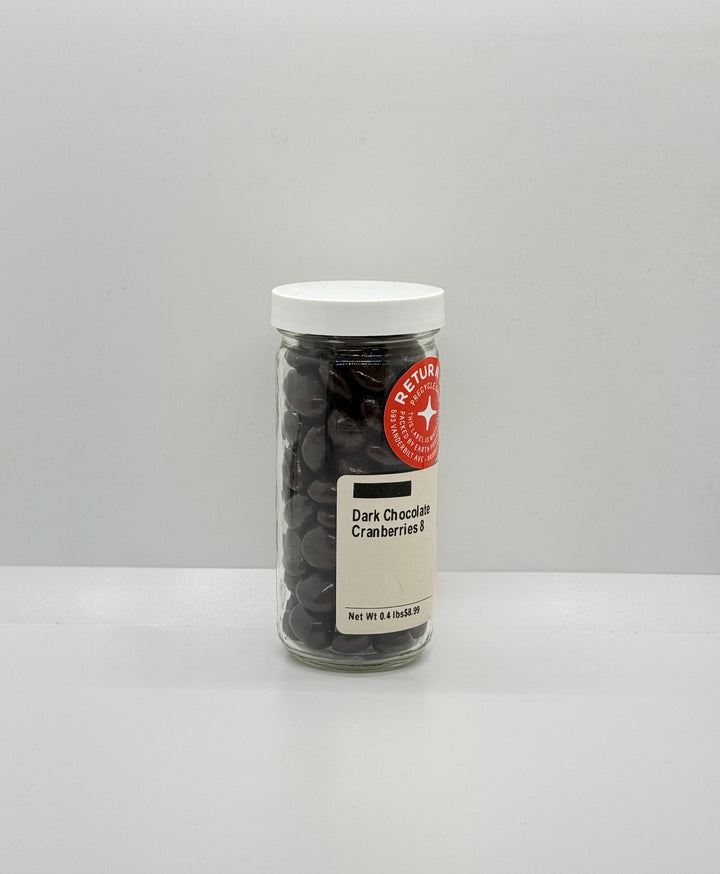Jar of dark chocolate cranberries with a white lid on a gray background