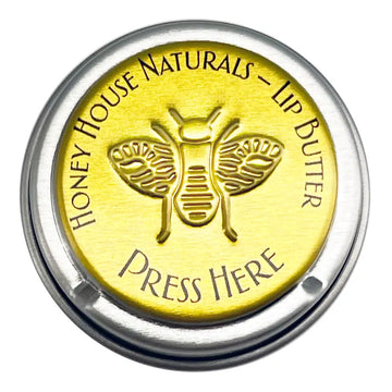 Honey House Naturals lip butter container with bee design and 'Press Here' text on a white background