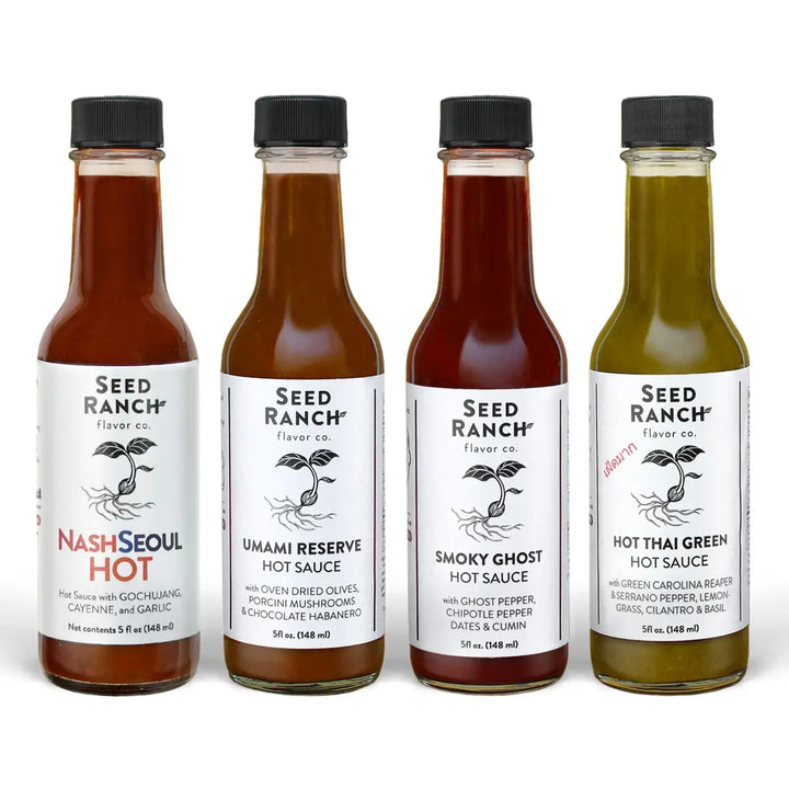 Four bottles of Seed Ranch hot sauce on a white background